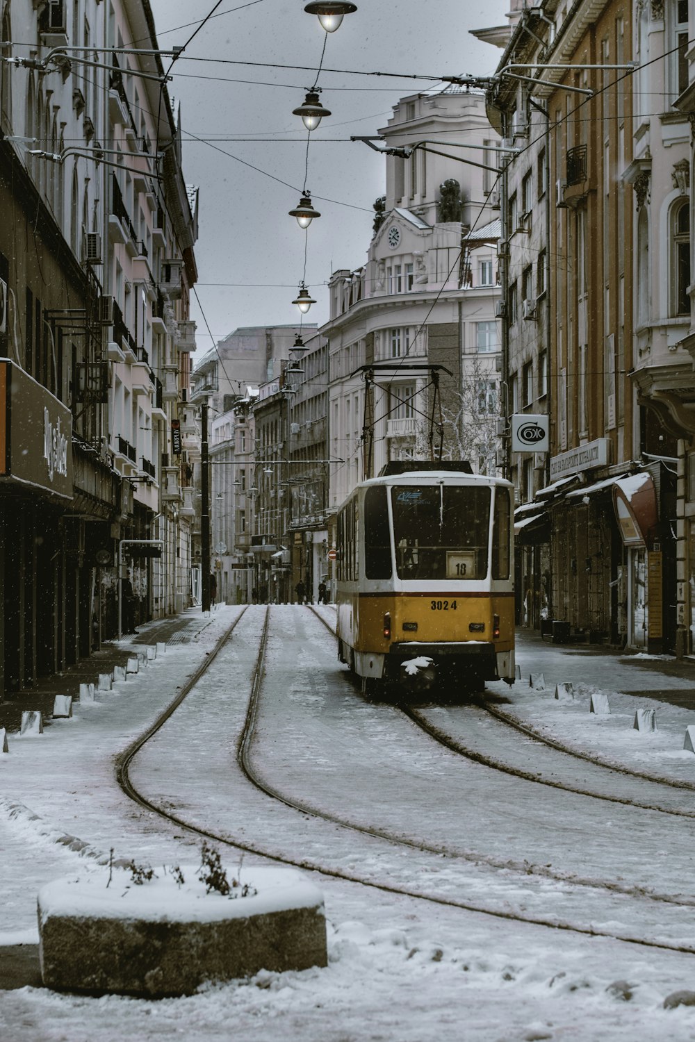 orange and gray train beside brown concrete building \