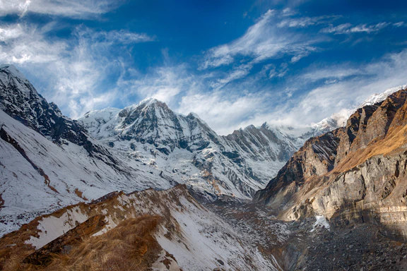 snow covered mountain under blue and white sky