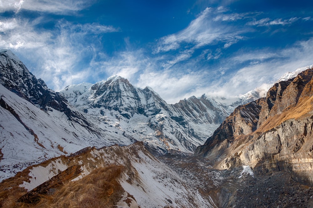 snow covered mountain under blue and white sky