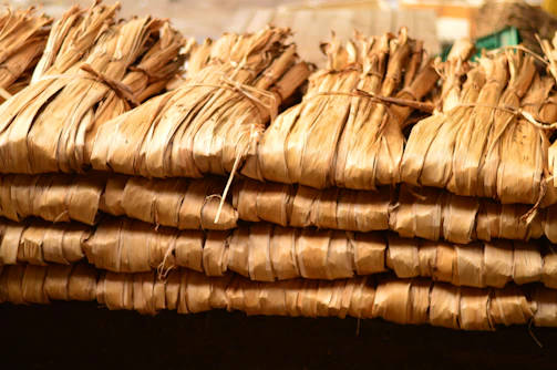 Bundles of dried long pepper (cabe jawa) neatly arranged on woven mats ready for export.