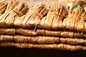 Bundles of dried bhringraj leaves arranged on rustic wooden table.
