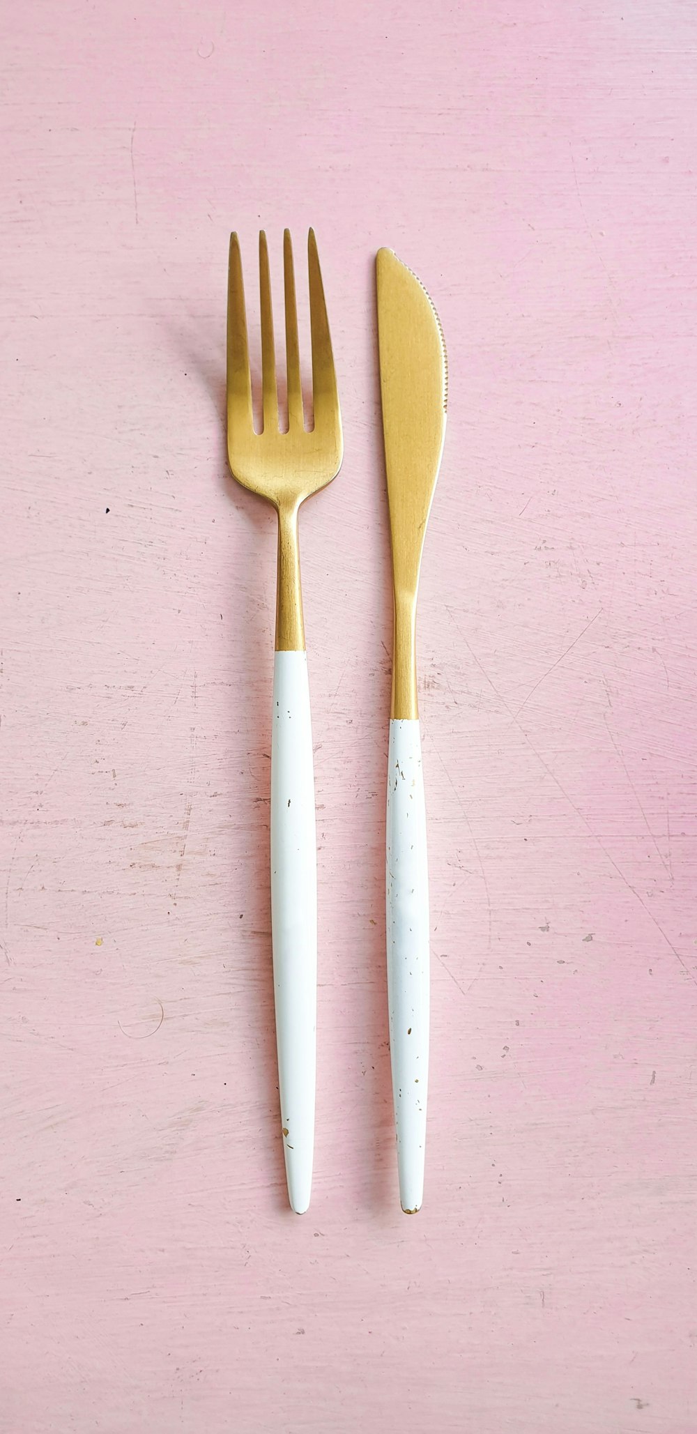 白と真鍮のフォークとブレッドナイフのペア