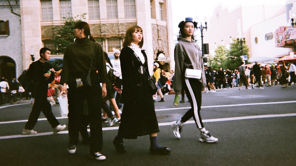 three women walking on road