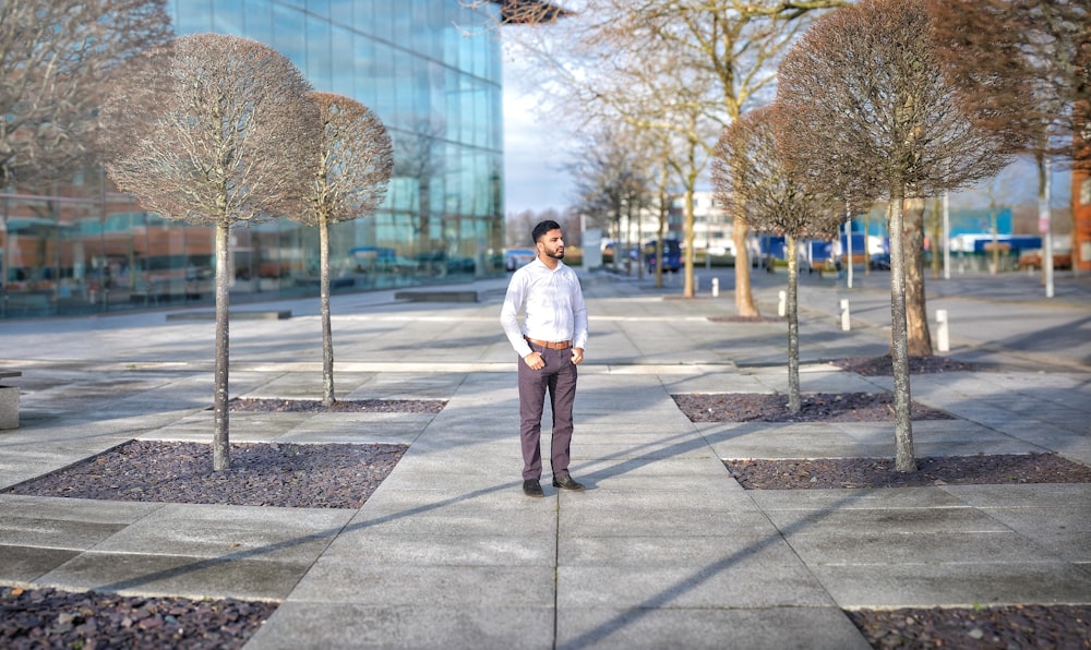 man standing beside brown trees during daytime