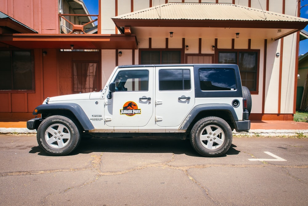 white vehicle parked near white and brown building