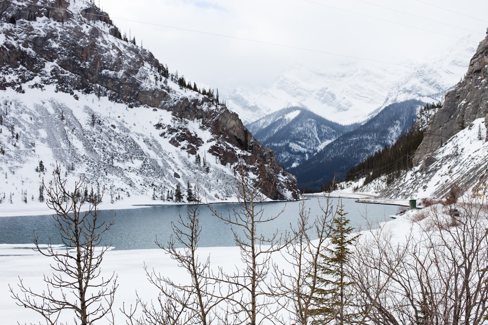 body of water surrounded by snow covered mountain