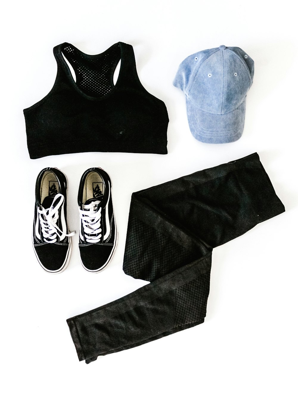 schwarzer Damen-Sport-BH, blaue Kappe, ein Paar Vans-Sneaker und schwarze Denim-Jeans