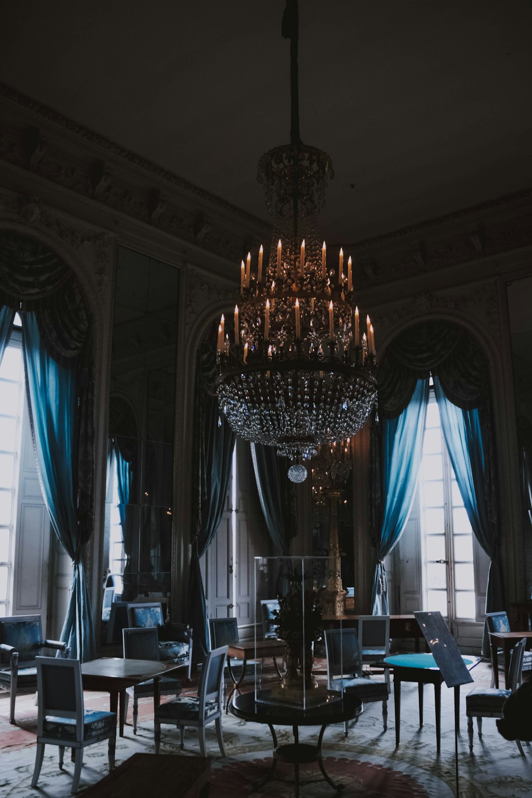 empty dining chairs under chandelier