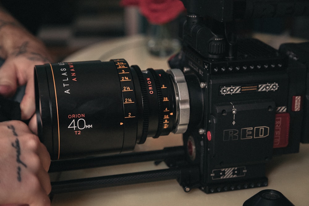 person holding black Red video camera