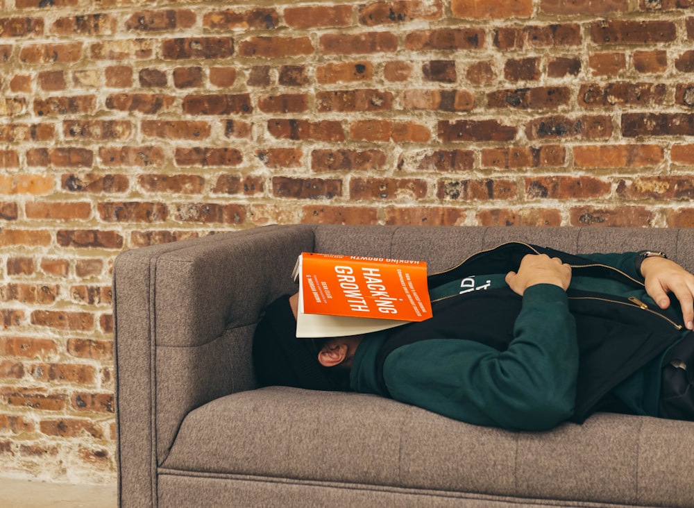 person sleeping on sofa near the wall