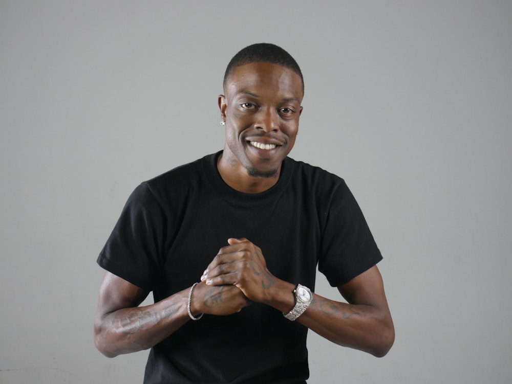 man wearing black crew-neck t-shirt showing fist