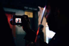 person under the umbrella holding digital camera