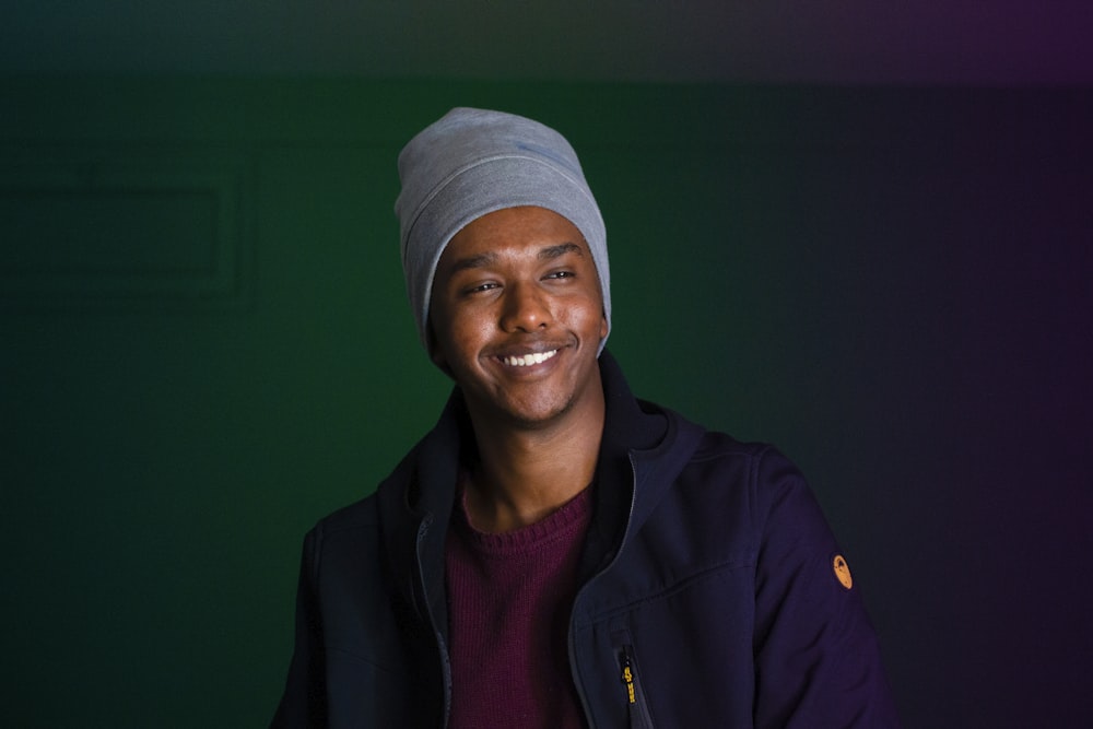 smiling man wearing knit cap and blue jacket