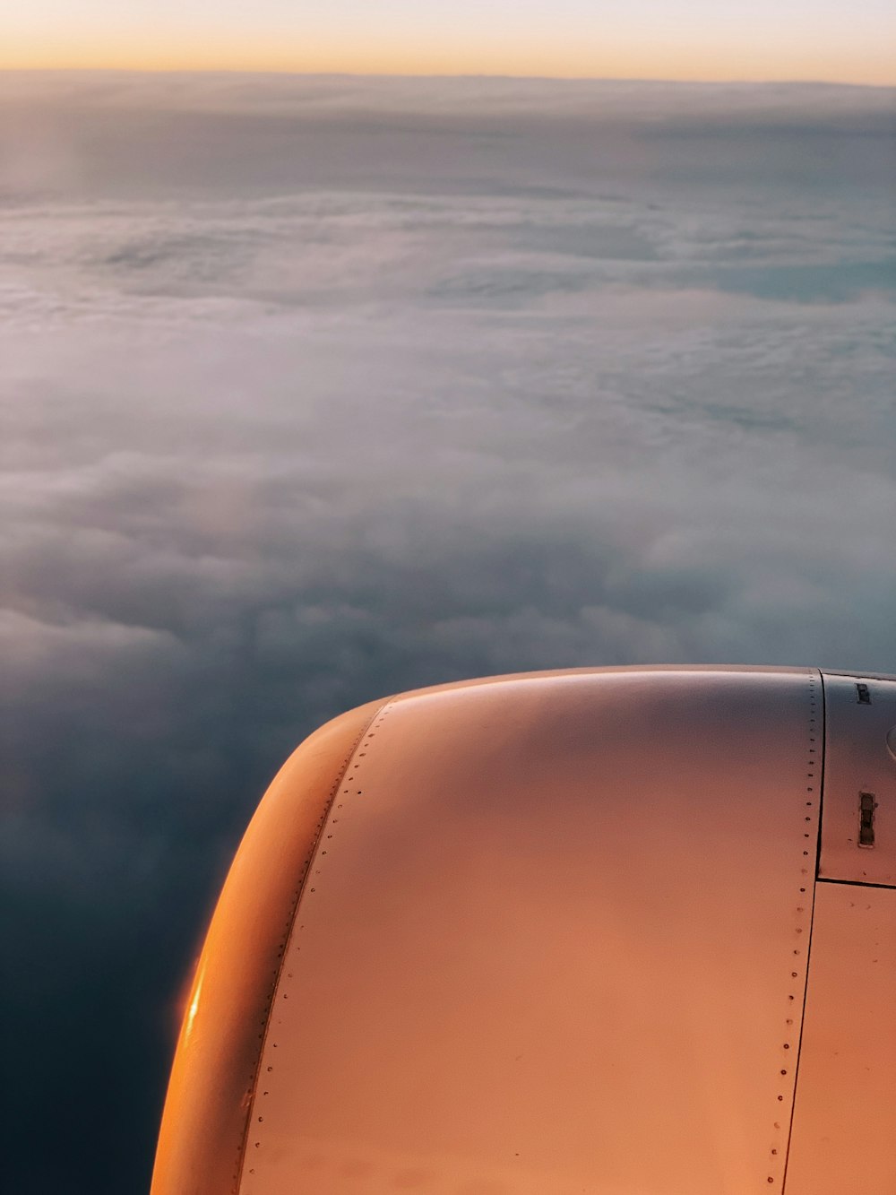 person riding airliner with view of right engine during golden hour