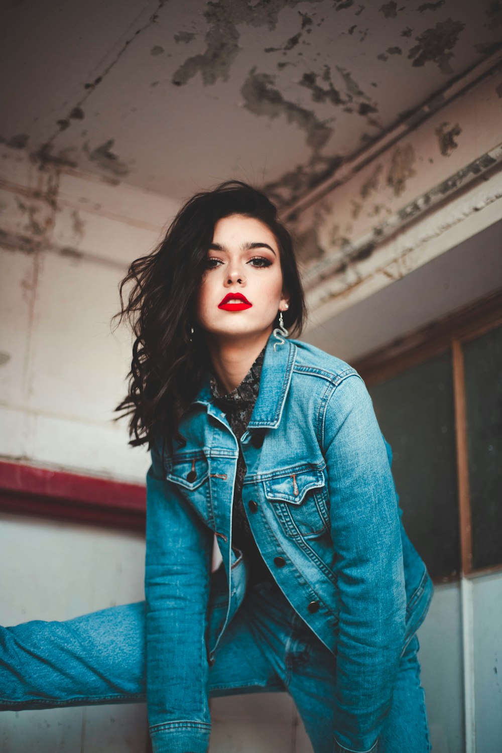 woman wearing blue denim jacket and pants raising right foot