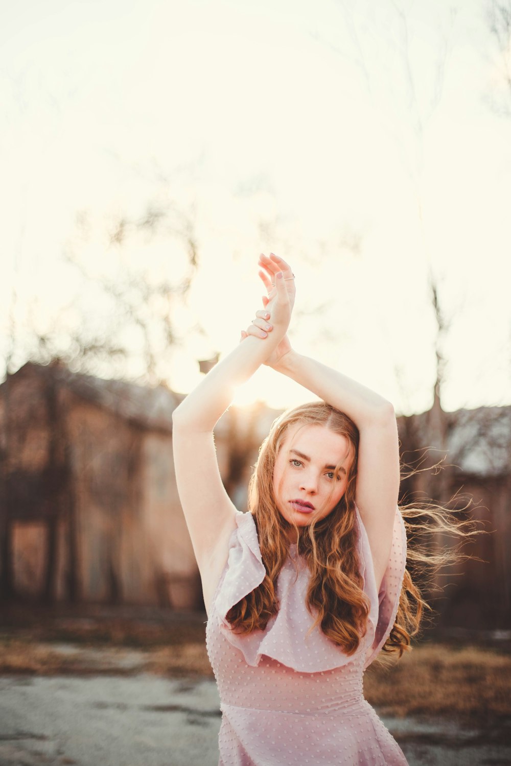 woman holding her hands upward standing near trees