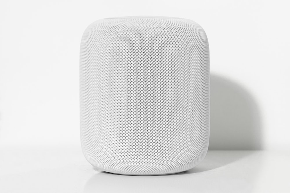 tubular white Bluetooth speaker on white surface