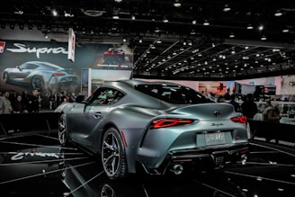 gray sports coupe parked in shop