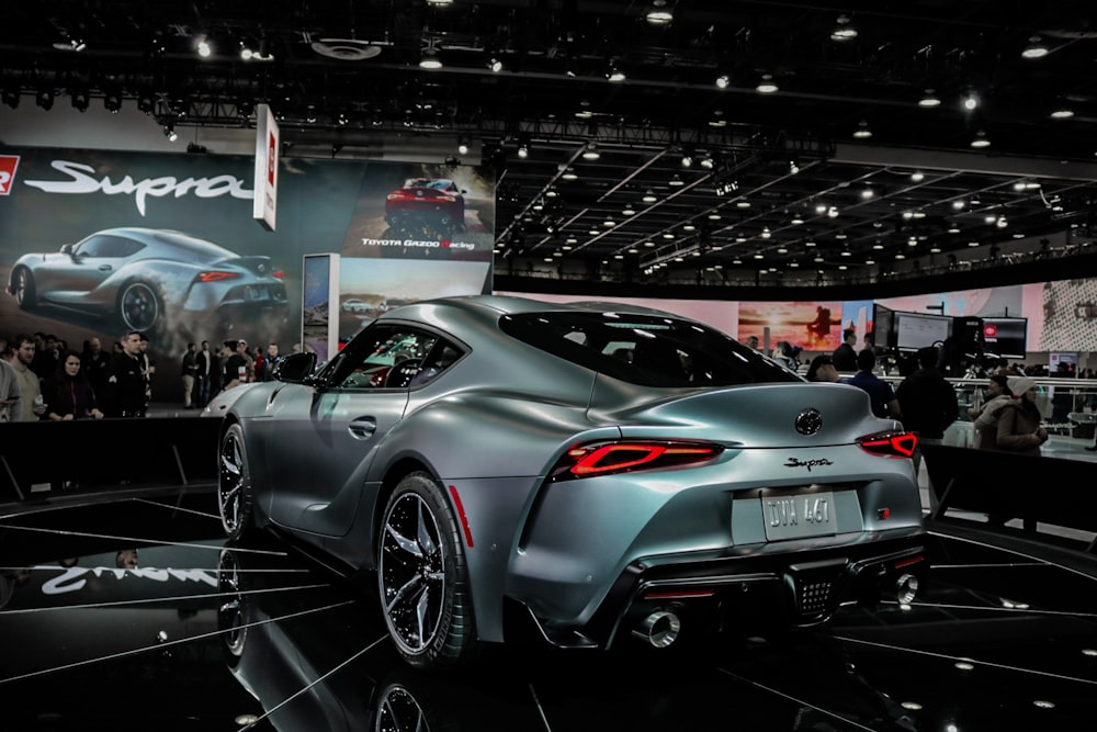 gray sports coupe parked in shop