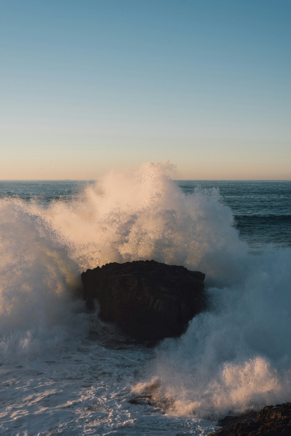 sea waves crashing on rock during daytime