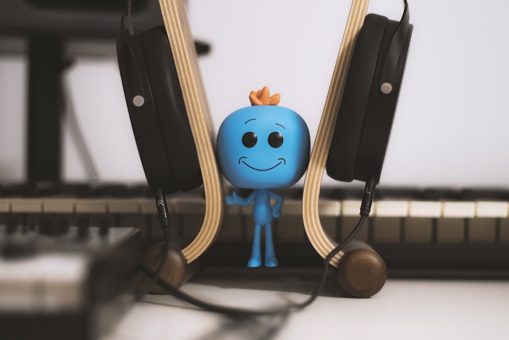 blue male figure wearing headset close-up photography
