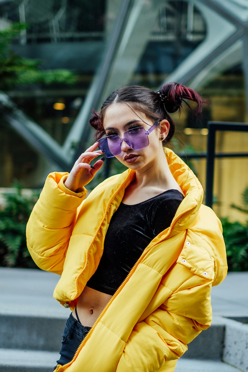 Outdoor waist up fashion portrait of young beautiful sensual woman wearing  stylish leather cap, trendy yellow sunglasses, sexy lace bra, tartan blazer,  posing in street of the city. Copy, empty space Stock