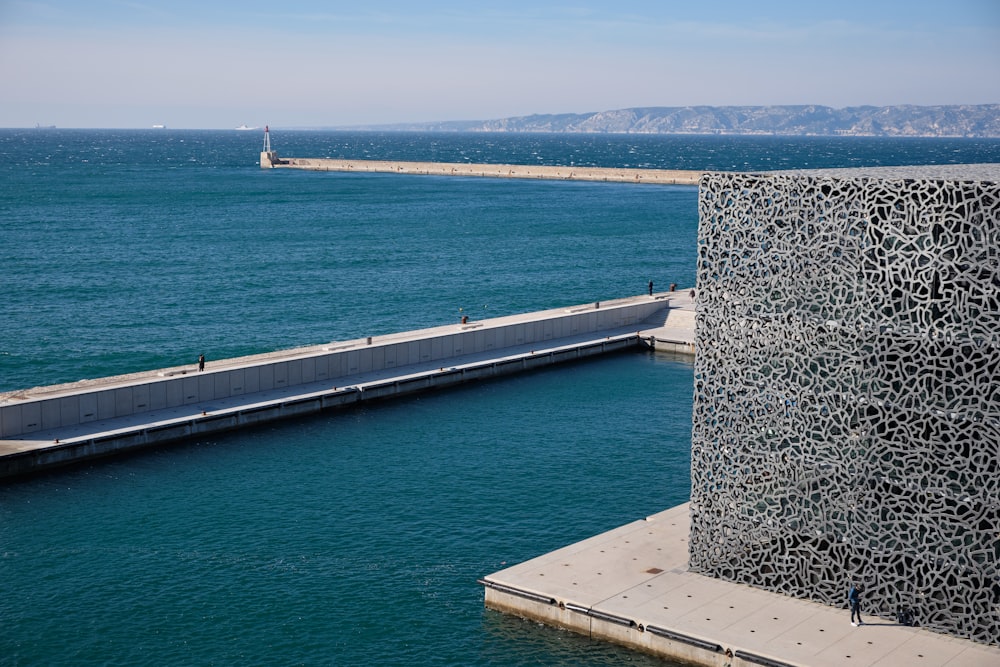 Photographie aérienne d’un pont près d’un bâtiment en béton gris pendant la journée