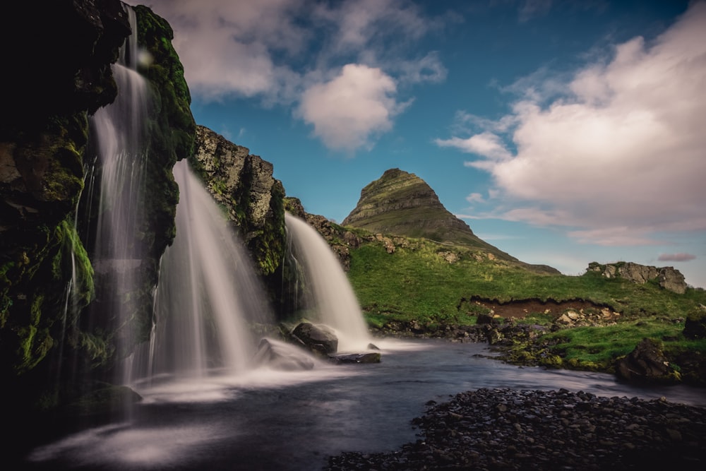 time-lapse photography of waterfalls near mountain during daytime