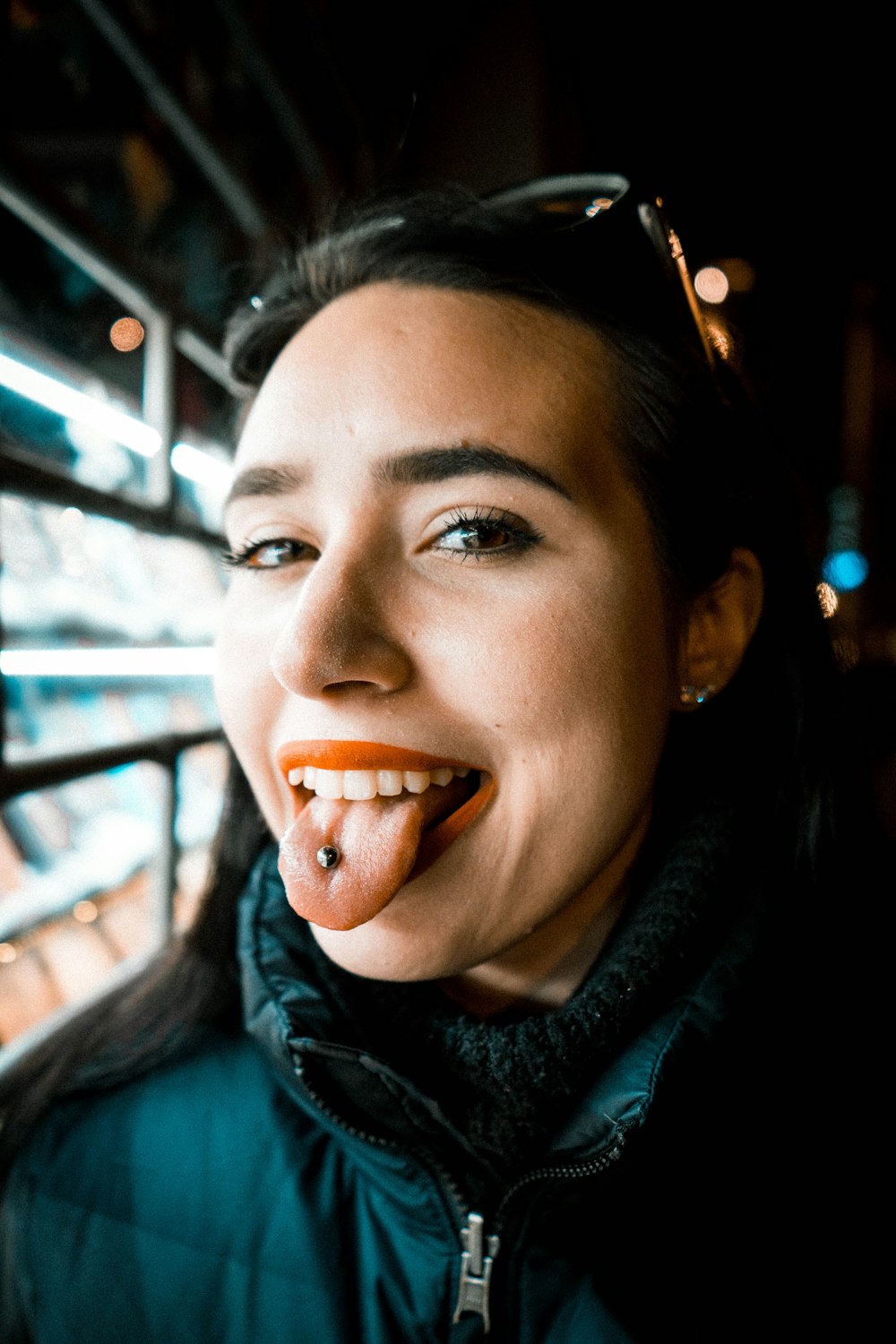 Frau zeigt Zunge mit Piercing