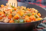 A close-up of a fresh vegetable stir-fry sizzling in a skillet.