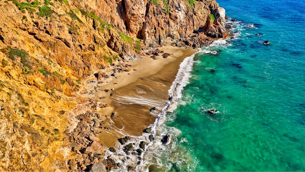 aerial photography of rock formation beside body of water