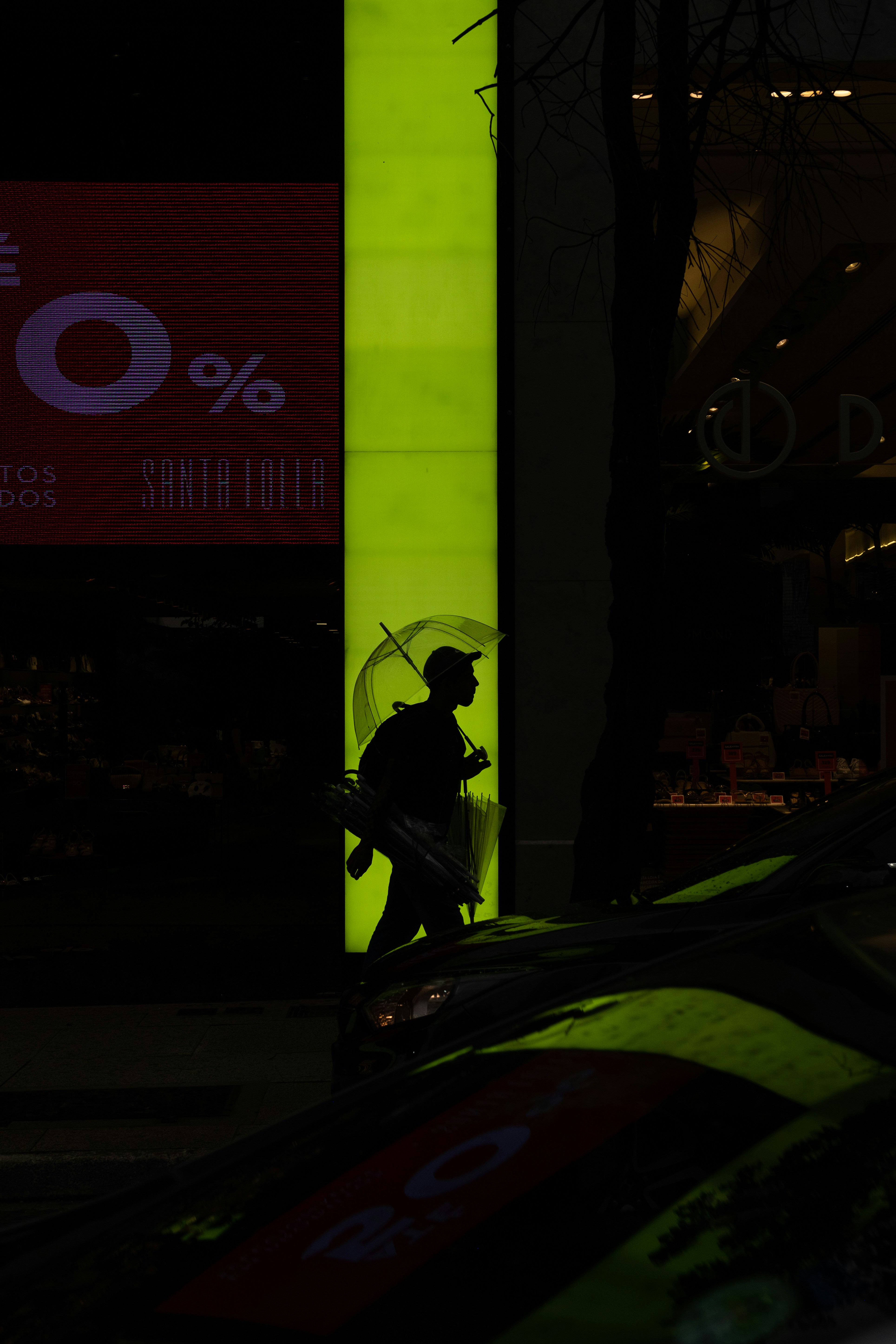 夜に傘をさして歩く男のシルエット