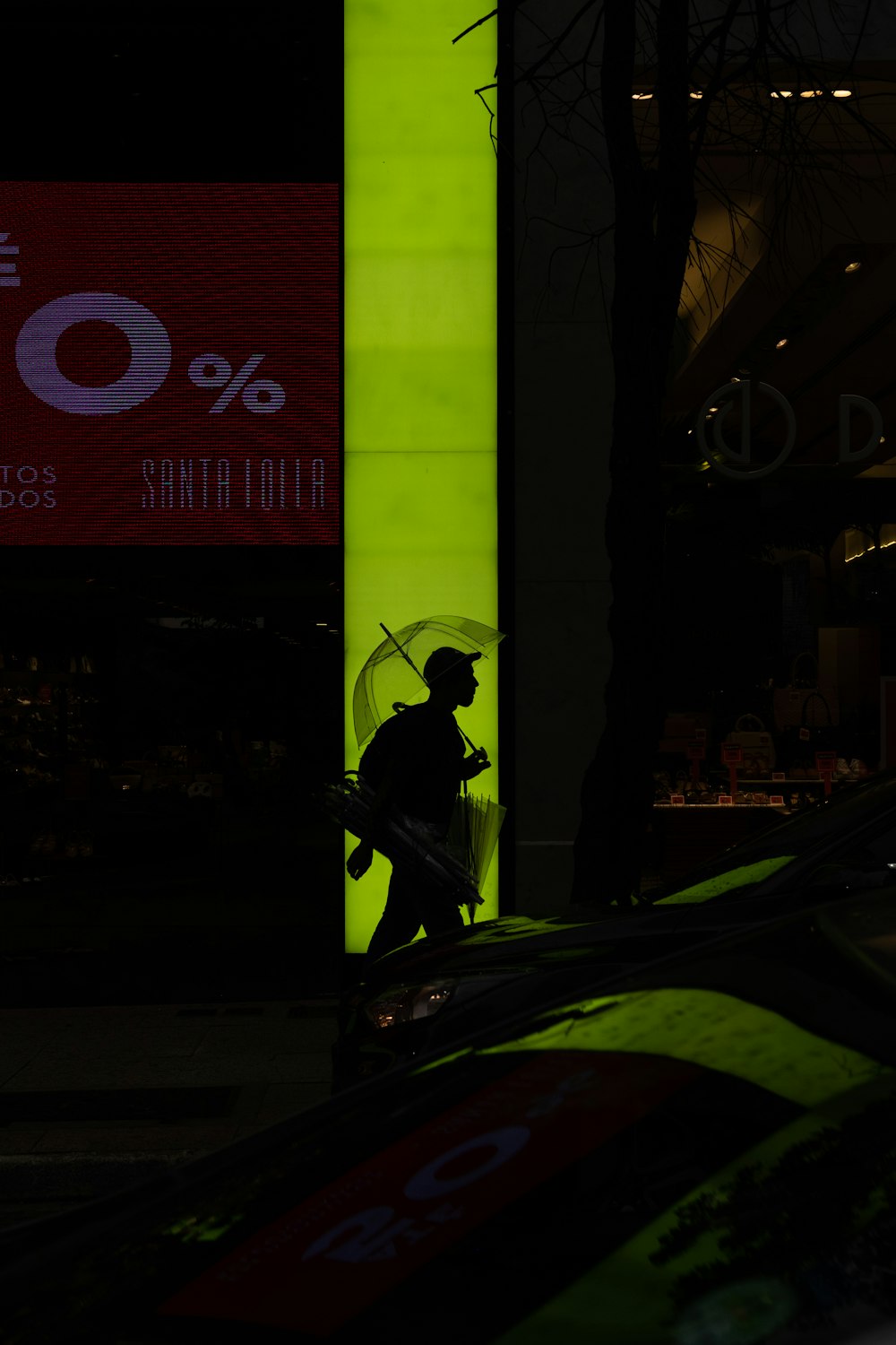 silhouette of man walking with umbrella at night