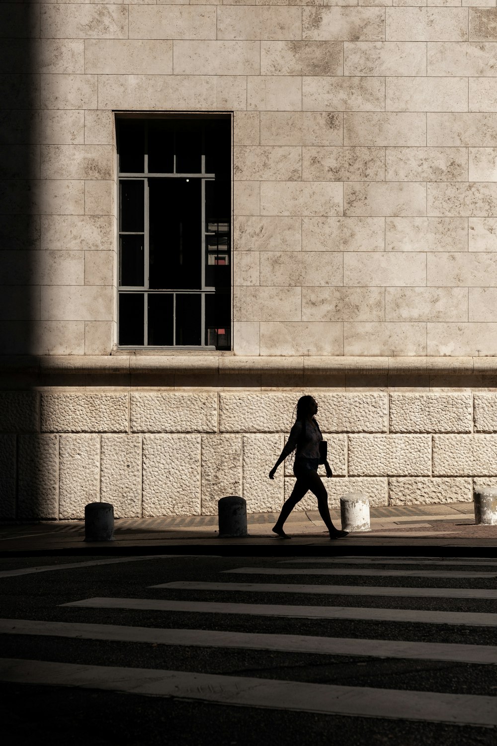 silhouette of girl walking near buildin