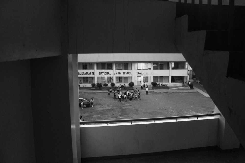 grayscale photography of people standing front of building
