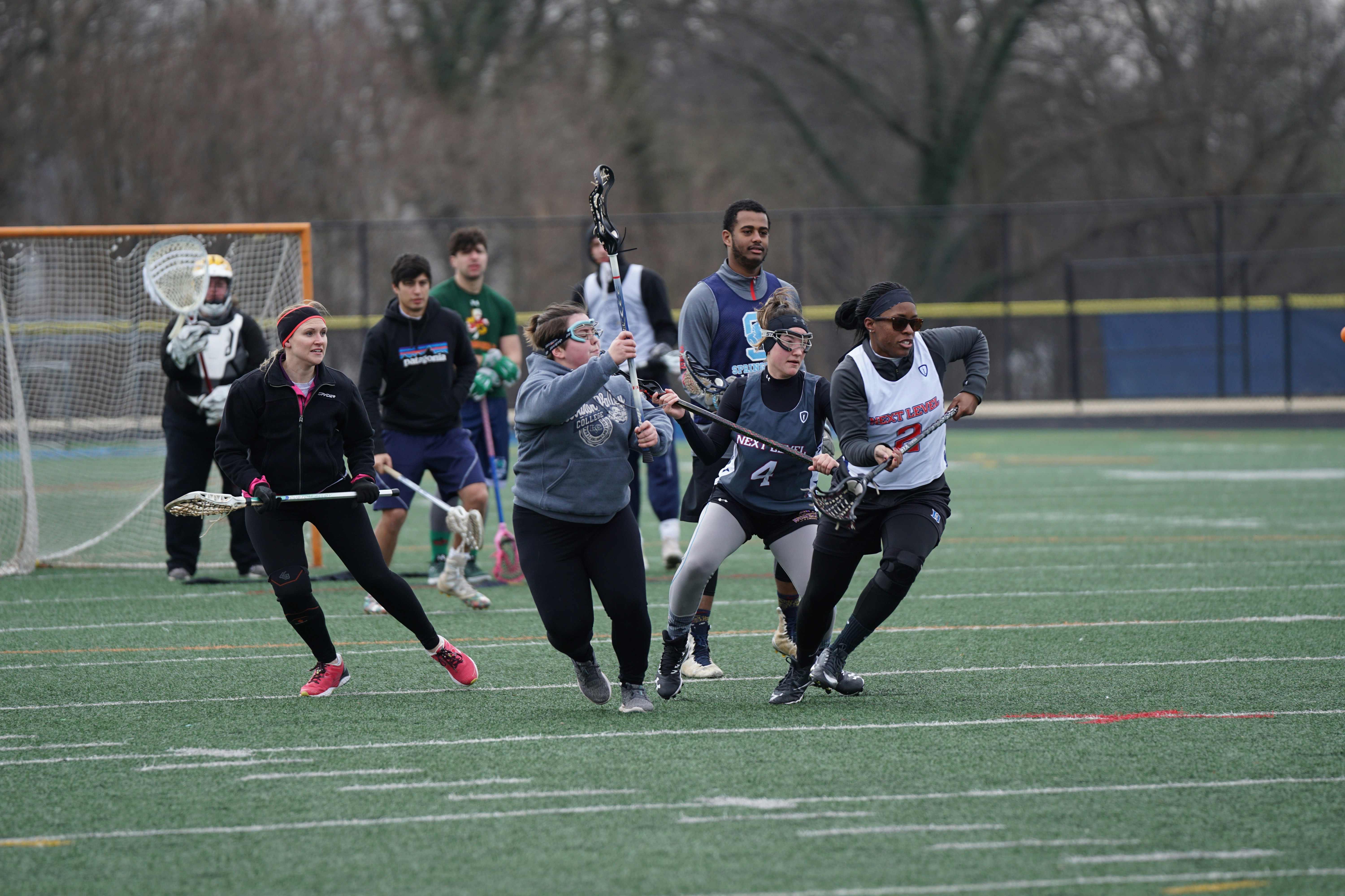 men and women playing lacrosse sport during daytime