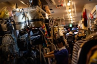 A cozy corner inside the store with various backpacks and purses on shelves.