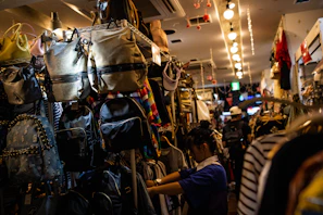 A selection of stylish backpacks and bags hanging on hooks in a bright shop.