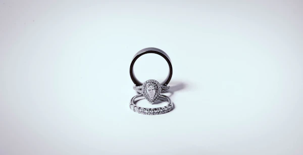 Silver pear-cut halo ring stacked with a plain band