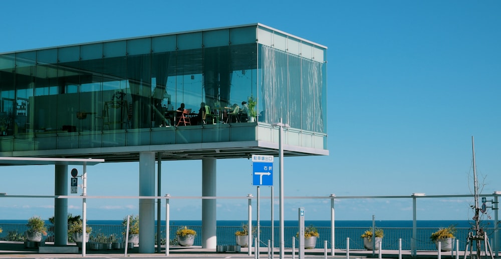 people on high elevated clear glass building with sea overlooking