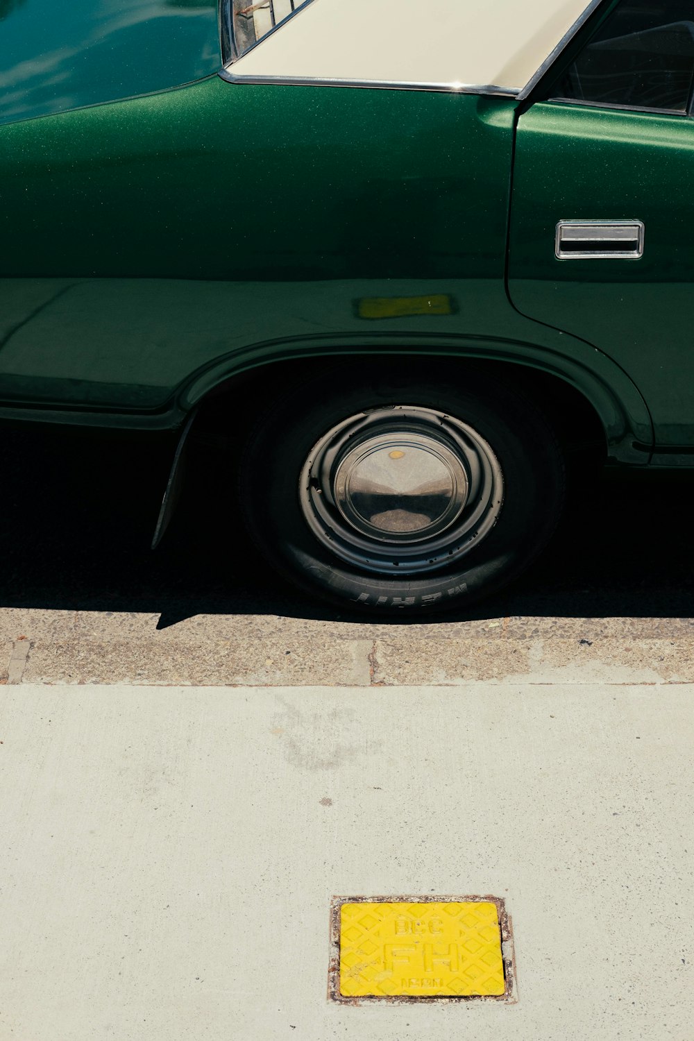 Un coche verde aparcado a un lado de la carretera