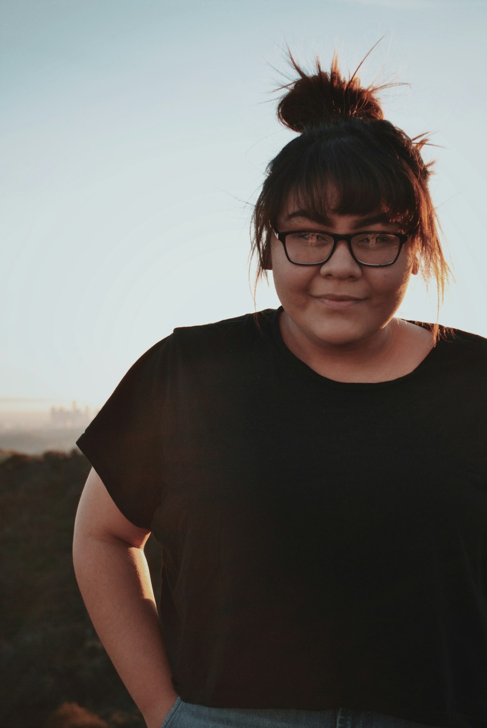 woman wearing black shirt standing while putting her hand in her pocket