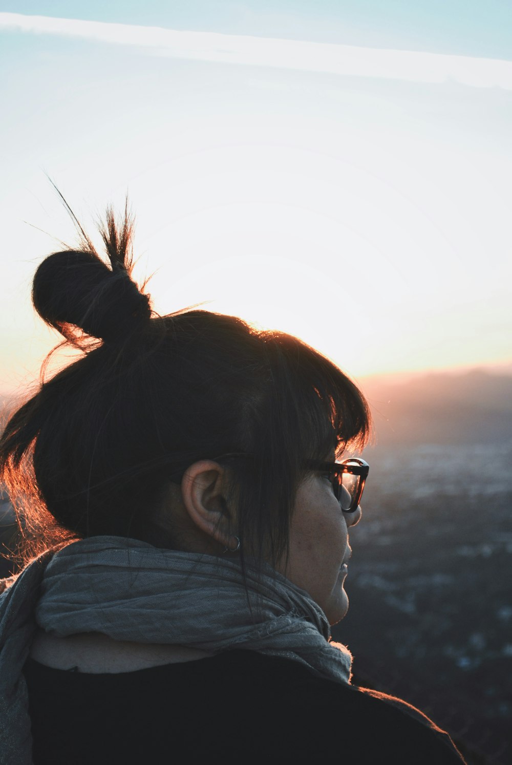 woman wearing gray scarf and black shirt during golden hour