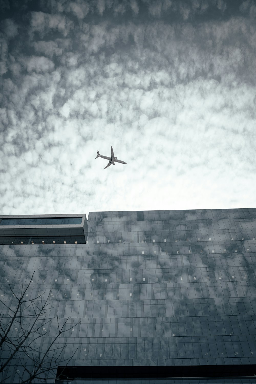 airliner on flight on top of gray high-rise building