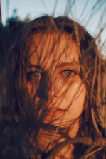 Close-up of a mestizo athlete's intense gaze, sun-kissed skin glowing with the texture of páramo grass in the background.