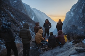 Group enjoying a warm bonfire in Manali, surrounded by the snow-covered Himalayan peaks