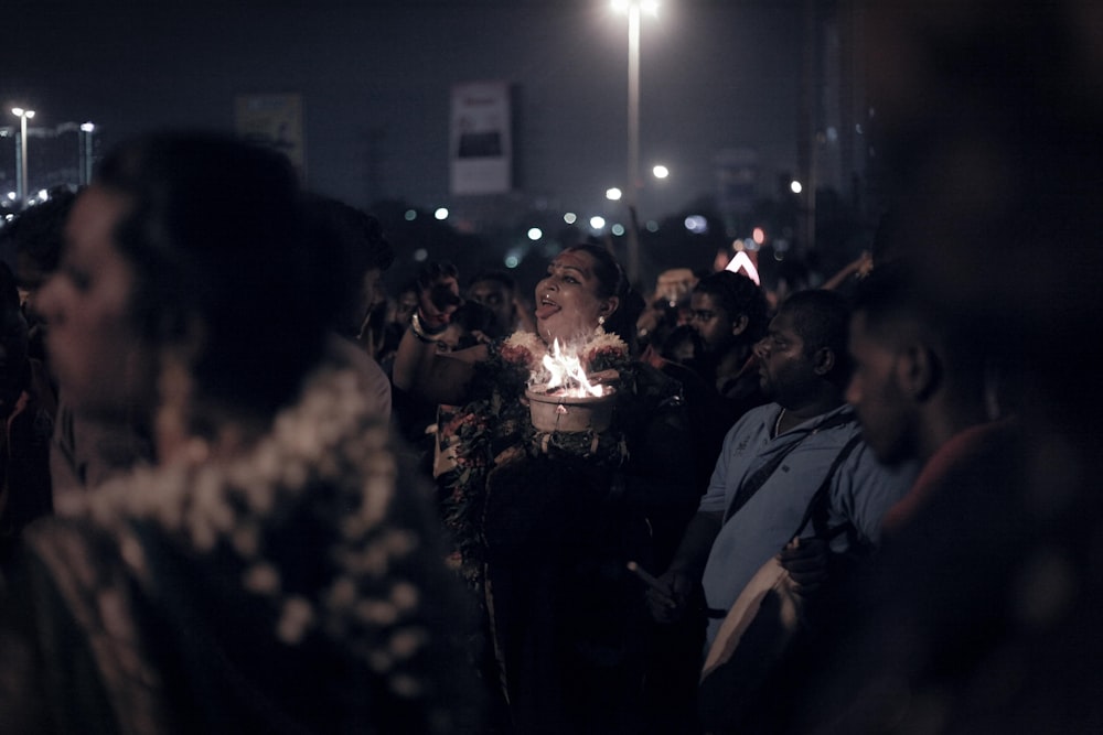 people standing beside concrete buildings at night