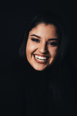 Close-up of a confident smile illuminated by soft, natural light highlighting genuine expression.