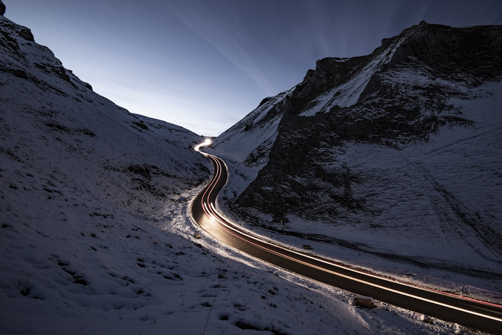 curvy road in middle of snow covered mountain
