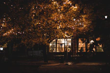 Evening exterior shot of Le Puits Enchanté illuminated by soft garden lights.